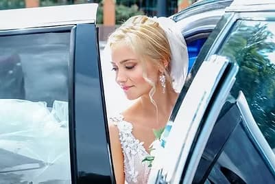 Bride stepping out of luxury car